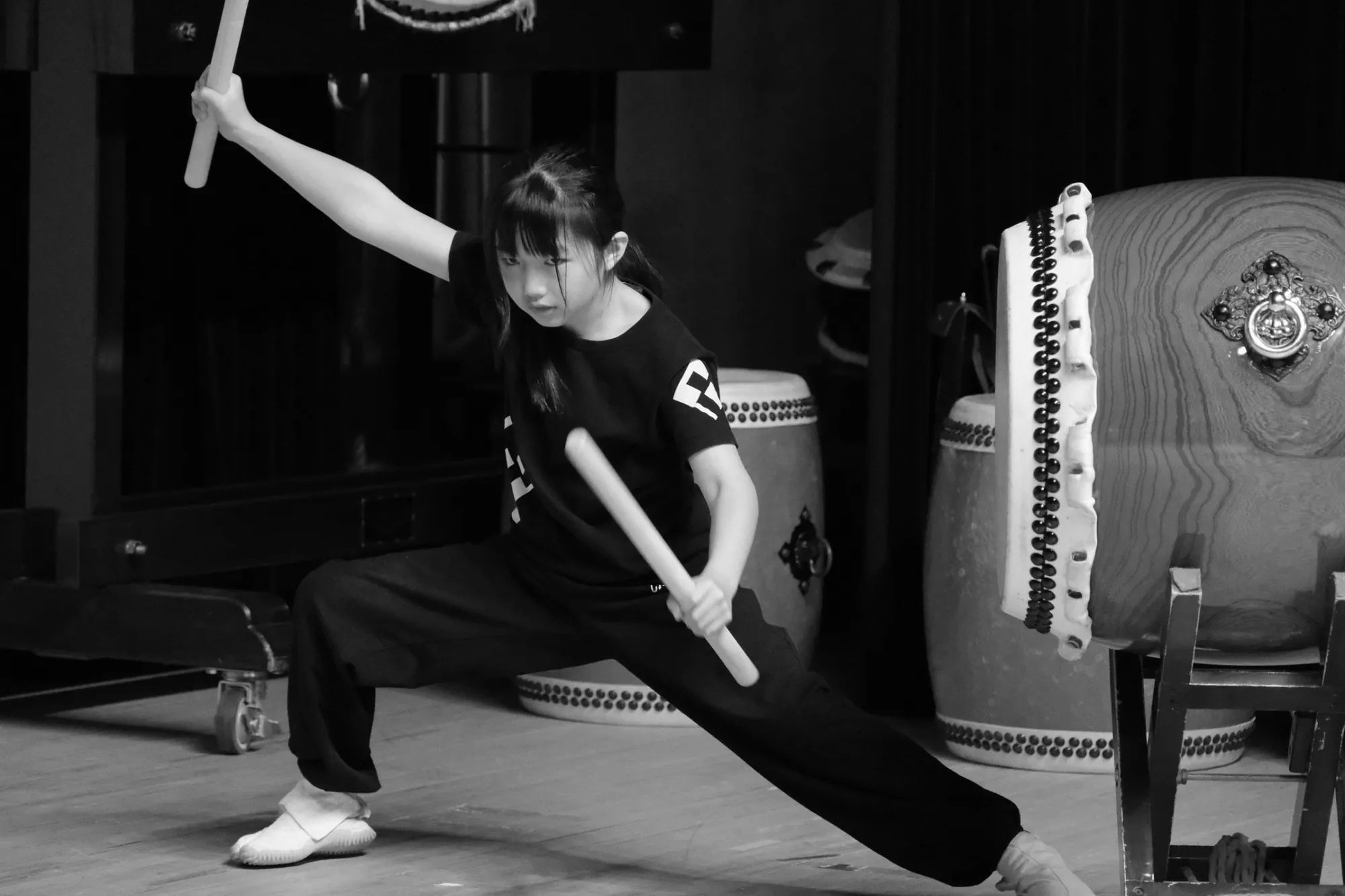 低い構えで撥を掲げる塾生